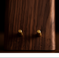Close-up detail of brass pegs on Oakstead walnut phone stand